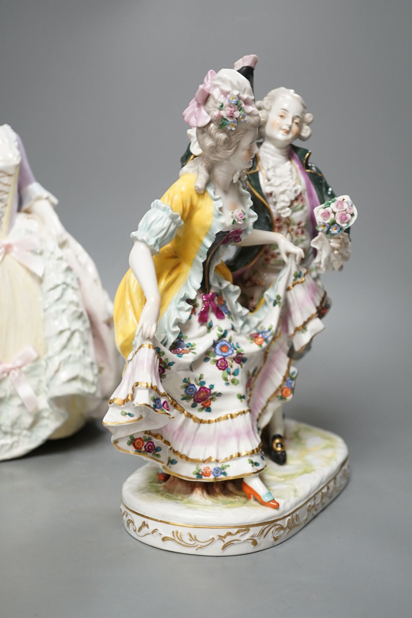 An Italian porcelain group of a dancing couple, 31cm, and an Italian maiolica figure of a lady